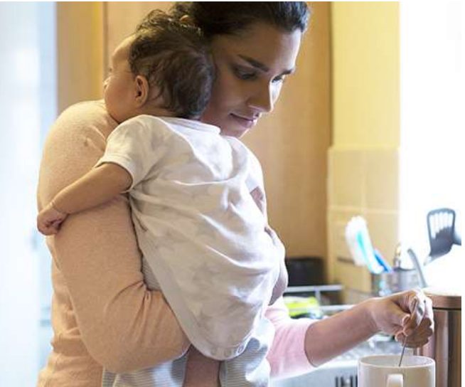 Parent holding baby and using Revomax bottle with one hand